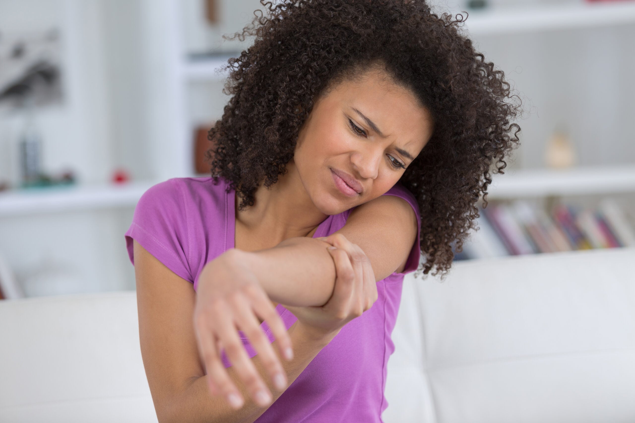 Person experiencing arm pain requiring chiropractic treatment in Campbell