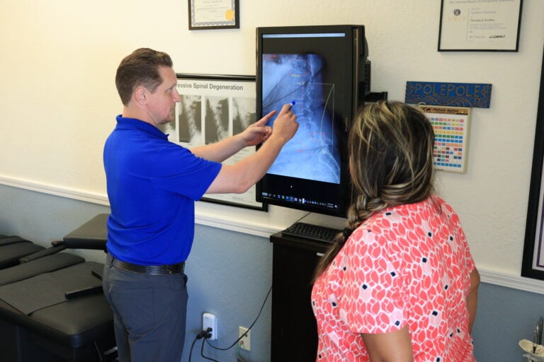 Chiropractor adjusting patient in treatment room